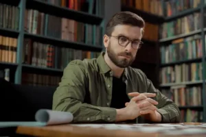 a man sitting at a table with his hands folded